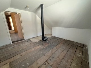 additional living space featuring vaulted ceiling and dark hardwood / wood-style flooring