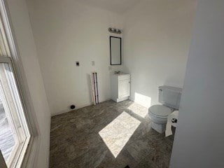 bathroom with toilet and a wealth of natural light