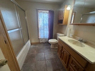 full bathroom featuring vanity, toilet, and combined bath / shower with glass door