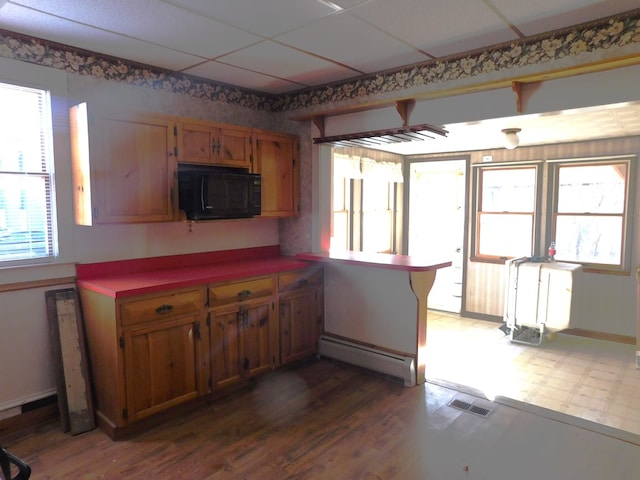 kitchen featuring tile patterned floors, visible vents, a drop ceiling, a baseboard heating unit, and black microwave