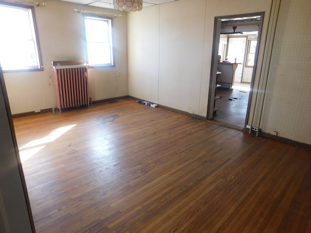 empty room featuring radiator and wood finished floors