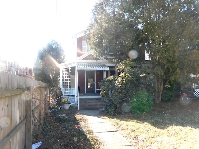 view of front of house featuring a porch and fence