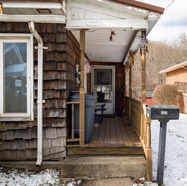 snow covered deck with a porch