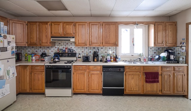 kitchen featuring decorative backsplash, a paneled ceiling, ventilation hood, sink, and black appliances