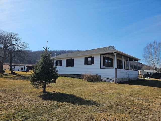 view of property exterior with a lawn and a sunroom