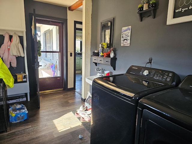 clothes washing area featuring a sink, separate washer and dryer, wood finished floors, and laundry area