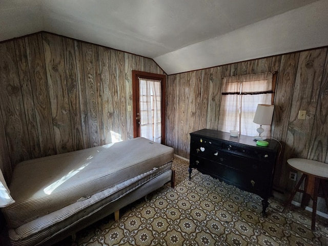 bedroom with wooden walls and lofted ceiling