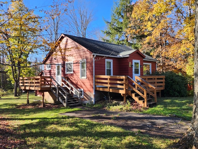 back of property featuring a lawn and a deck