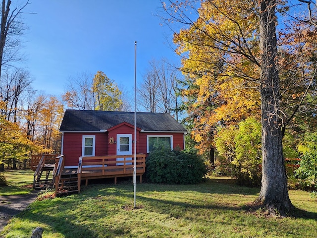 view of front of house with a front yard and a deck