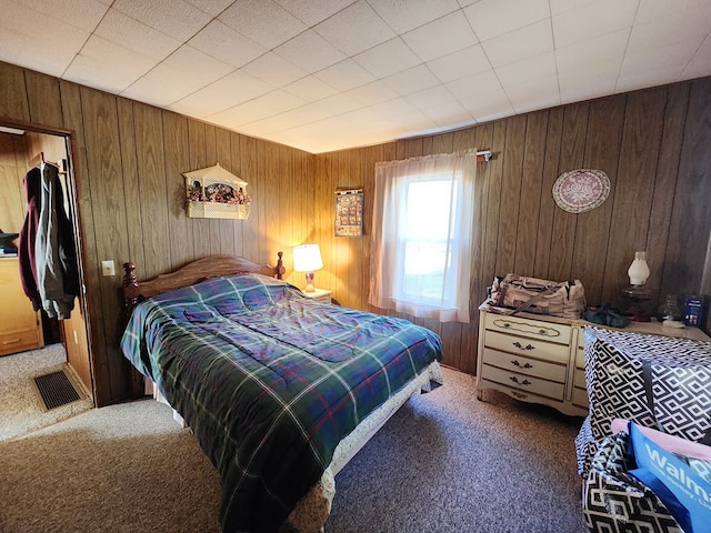 bedroom featuring carpet flooring and wooden walls