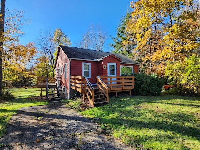 rear view of property featuring a wooden deck and a yard