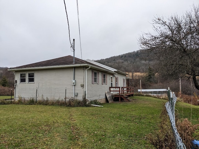 view of property exterior with a deck and a yard