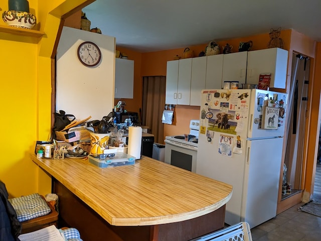 kitchen featuring kitchen peninsula and white appliances