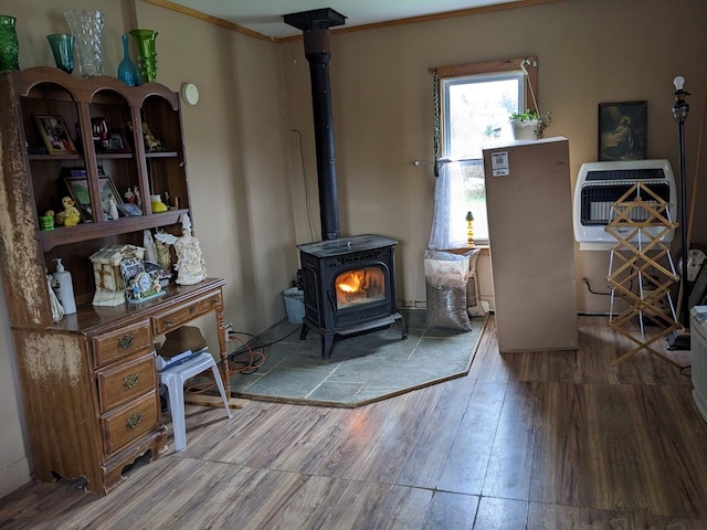 living room with hardwood / wood-style floors, heating unit, and a wood stove