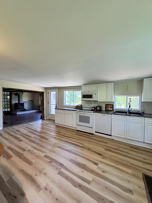 971 Indian Creek Rd, Eldred, PA 16731 - kitchen with white appliances, dark countertops, light wood-style floors, open floor plan, and a wood stove
