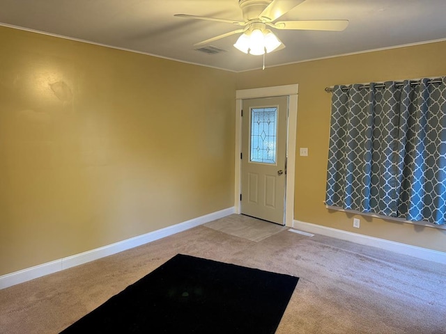 foyer entrance featuring light colored carpet, baseboards, ceiling fan, and visible vents