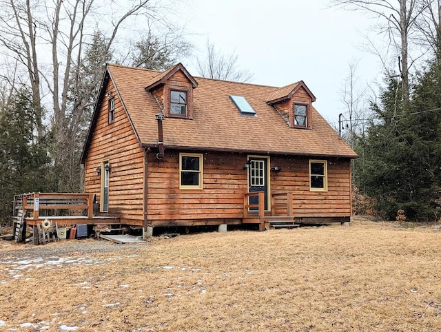 view of front of house featuring roof with shingles and a wooden deck