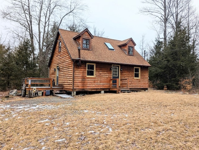 exterior space with a deck and roof with shingles