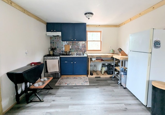 kitchen featuring blue cabinets, light wood finished floors, freestanding refrigerator, stainless steel range with electric stovetop, and under cabinet range hood