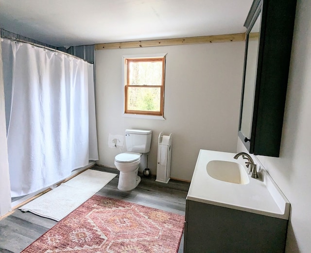 bathroom with toilet, a shower with shower curtain, wood finished floors, and vanity