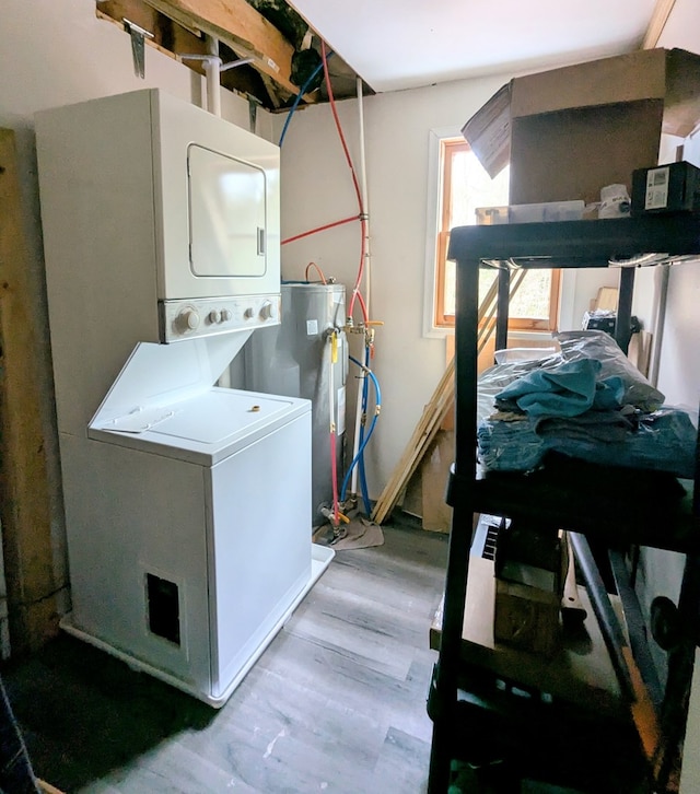 laundry area with stacked washer and dryer, laundry area, water heater, and light wood finished floors