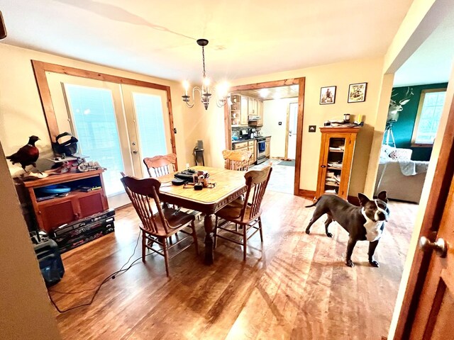 dining room featuring french doors, wood-type flooring, and a notable chandelier