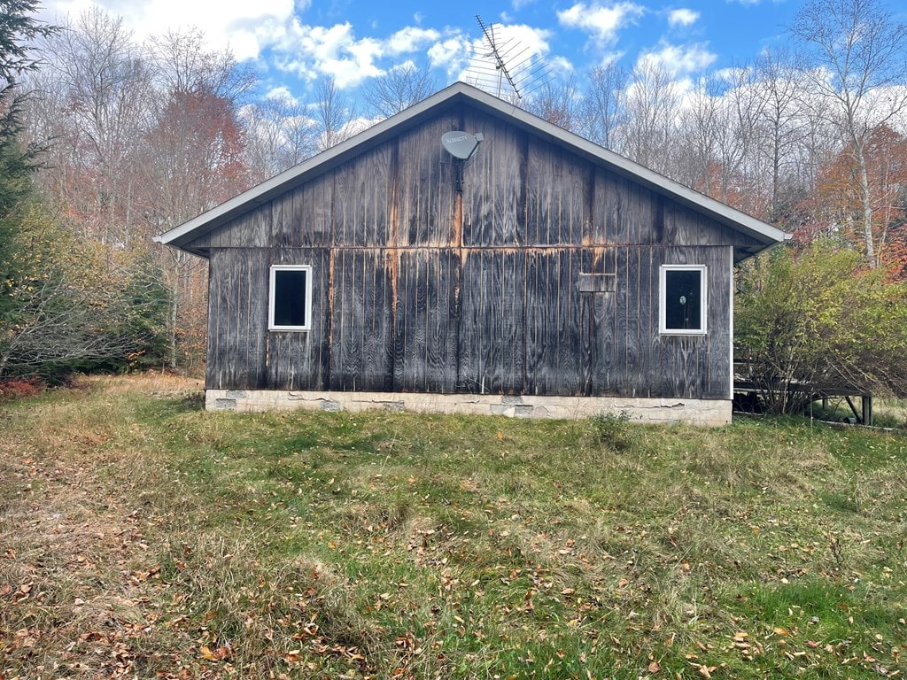 view of side of home featuring a yard and an outdoor structure