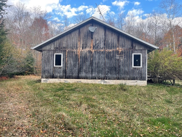 view of side of home featuring a yard and an outdoor structure