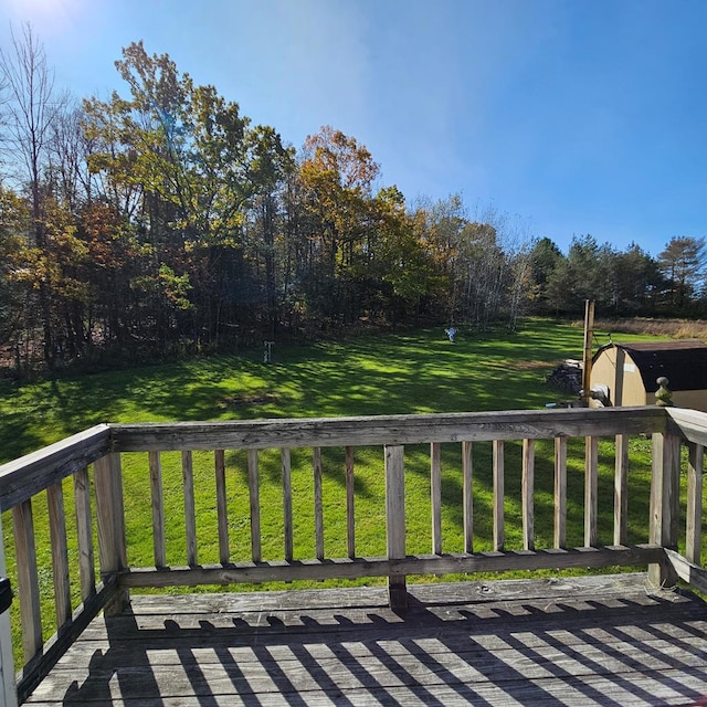 wooden terrace featuring a lawn