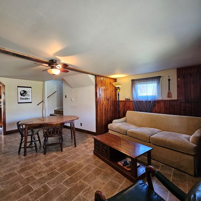 living room featuring wood walls and ceiling fan