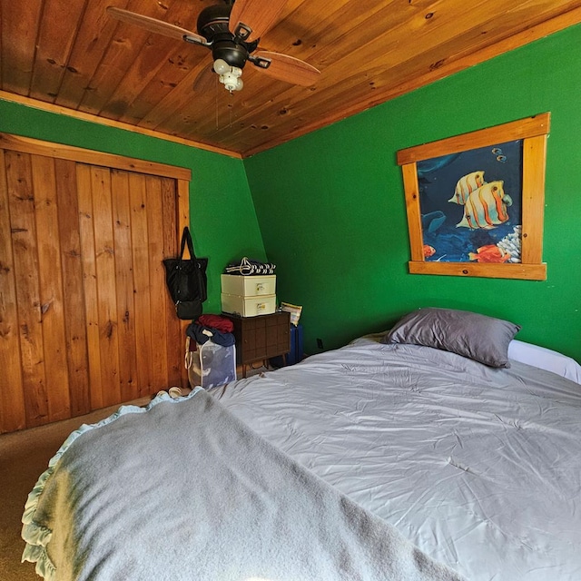 carpeted bedroom featuring ceiling fan, wood ceiling, and ornamental molding