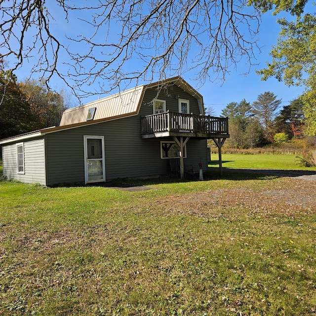 rear view of property with a lawn and a deck