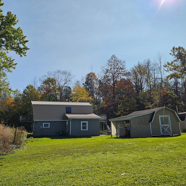 rear view of house with a yard and a storage shed