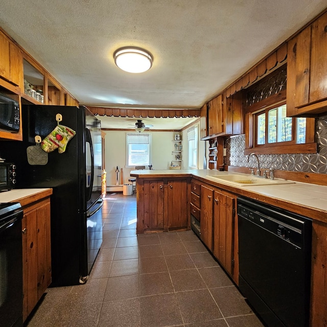 kitchen with black appliances, sink, ceiling fan, a textured ceiling, and kitchen peninsula