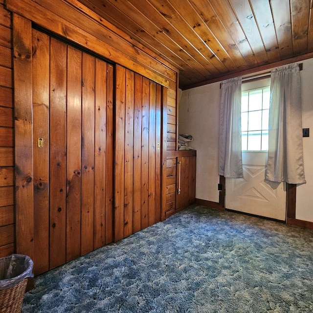 carpeted empty room with wooden walls and wooden ceiling