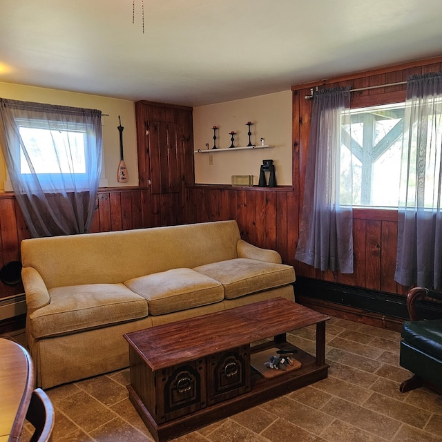 living room with wood walls, plenty of natural light, and a baseboard heating unit