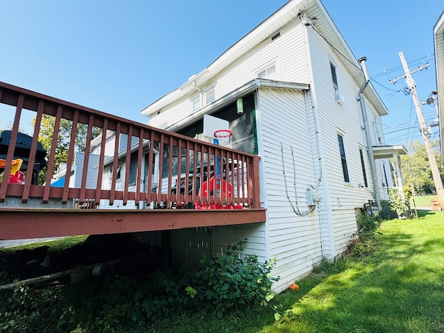 view of side of property with a deck and a lawn