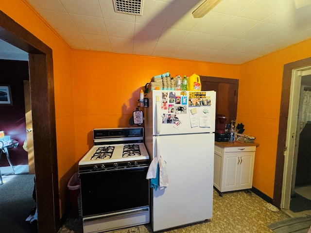 kitchen with white cabinetry and white appliances