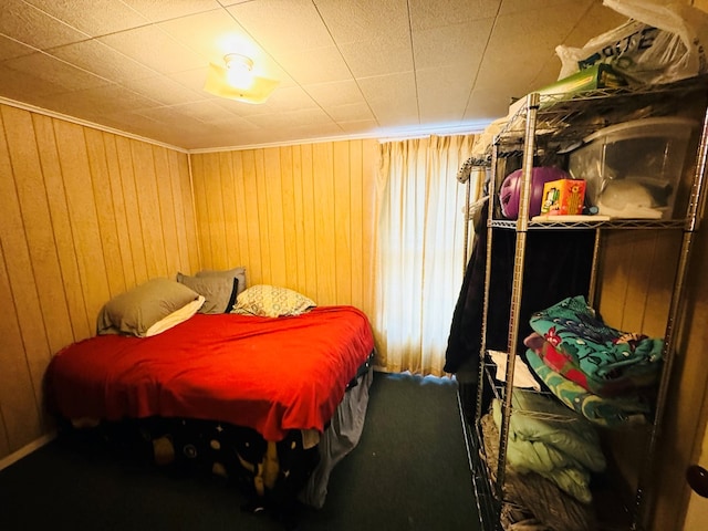 carpeted bedroom featuring wooden walls