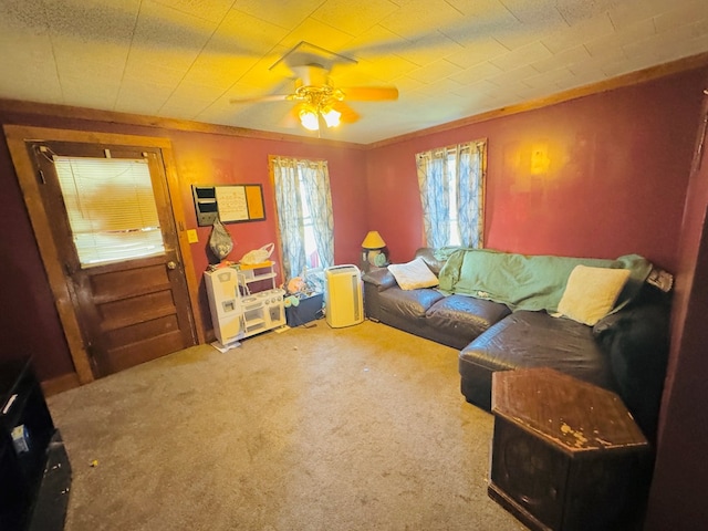 carpeted living room featuring ceiling fan and ornamental molding