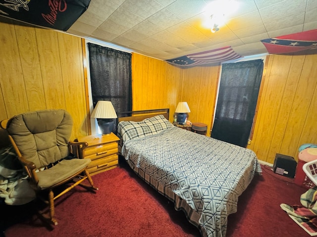 bedroom with wood walls and dark carpet