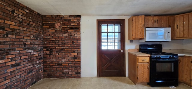 kitchen with black gas range, brick wall, and a textured ceiling