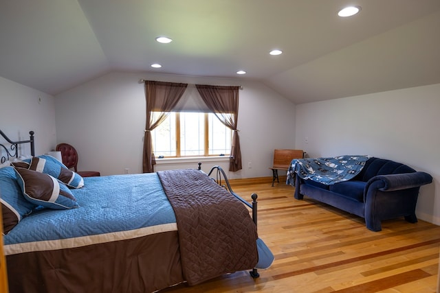 bedroom with wood-type flooring and vaulted ceiling