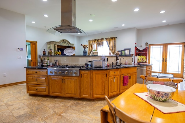 kitchen featuring sink, island exhaust hood, dark stone counters, and stainless steel appliances