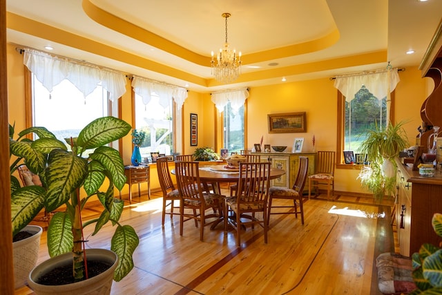 dining room featuring hardwood / wood-style flooring, a chandelier, and a tray ceiling