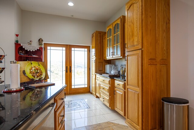 kitchen with dark stone countertops, french doors, and light tile patterned flooring