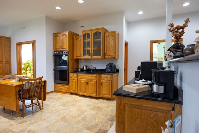 kitchen with sink, dark stone countertops, and black double oven