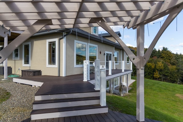 property entrance with a lawn, a pergola, a deck, and central AC