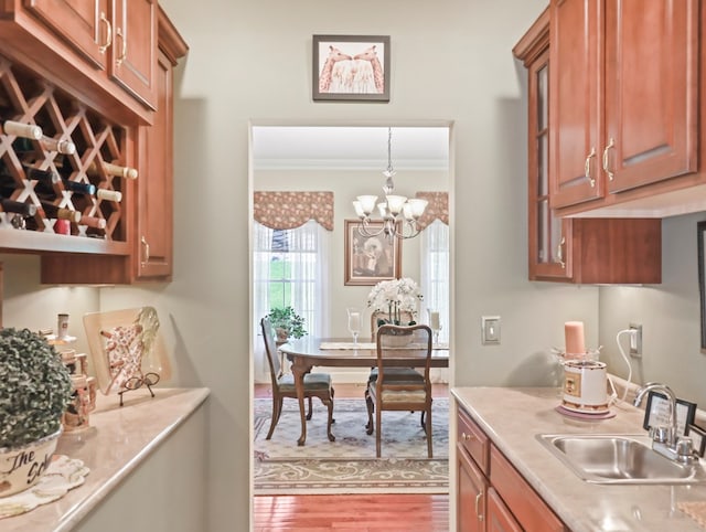 335 Sullivan Dr, Sayre, PA 18840 - kitchen featuring a sink, crown molding, wood finished floors, light countertops, and a chandelier