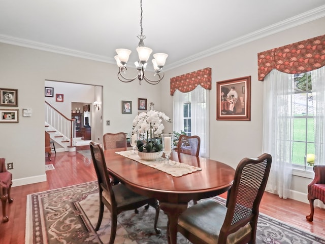 335 Sullivan Dr, Sayre, PA 18840 - dining space featuring crown molding, wood finished floors, a chandelier, stairs, and baseboards